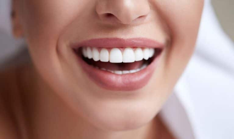 Close-up of person's smiling face showing bright, white teeth and healthy smile.